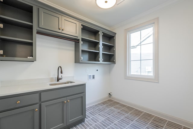 laundry area featuring electric dryer hookup, sink, washer hookup, cabinets, and ornamental molding