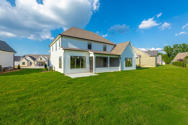 back of house with a lawn, a garage, and a patio area