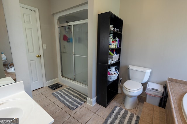 bathroom featuring tile patterned flooring, a shower with shower door, toilet, and vanity