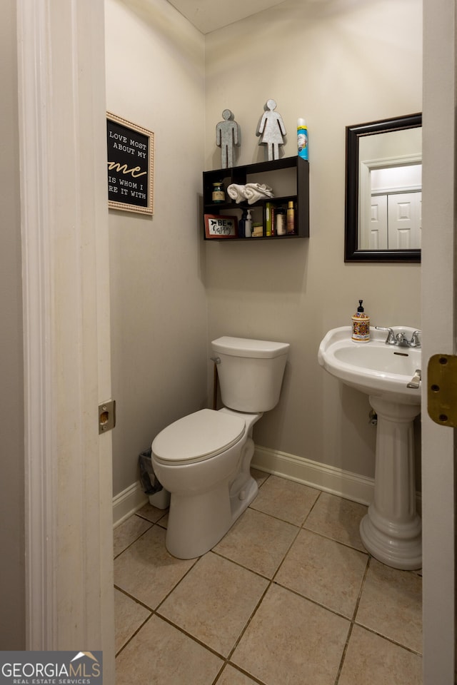 bathroom with toilet and tile patterned floors