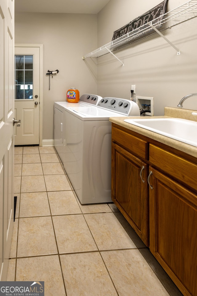 laundry area with washer and dryer, cabinets, sink, and light tile patterned floors