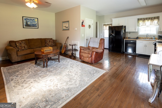 living room with ceiling fan, dark hardwood / wood-style floors, and sink