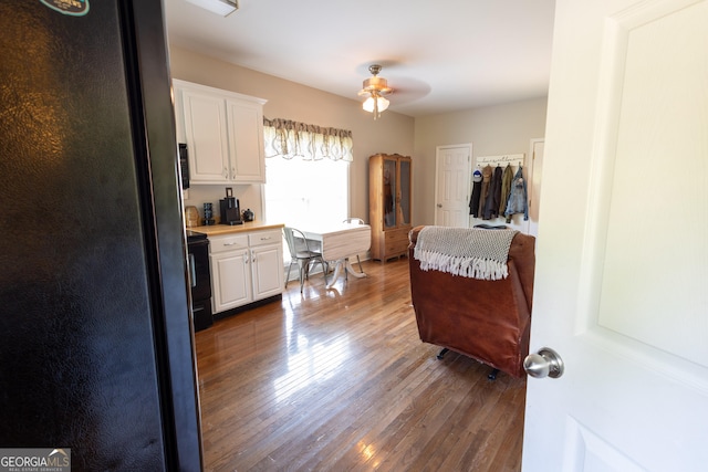 kitchen featuring black appliances, white cabinetry, dark wood-type flooring, and ceiling fan