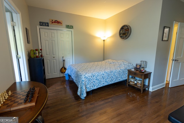 bedroom with dark hardwood / wood-style floors and a closet