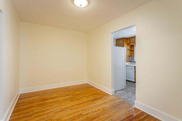 empty room featuring crown molding and light hardwood / wood-style flooring