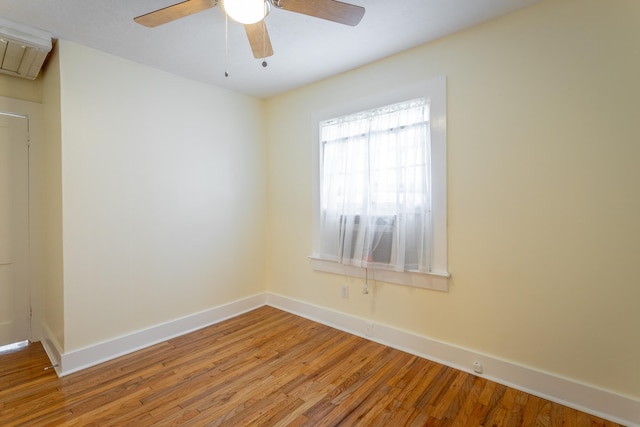 empty room with hardwood / wood-style floors and ceiling fan