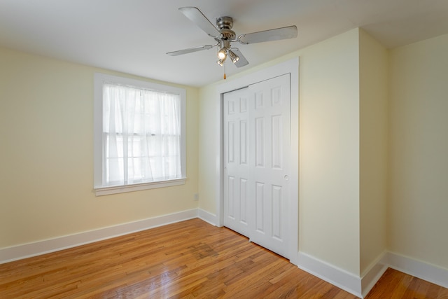 unfurnished bedroom with light hardwood / wood-style flooring, ceiling fan, and a closet