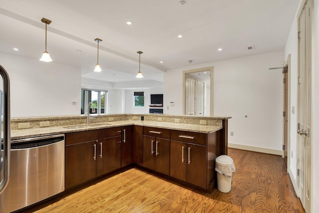 kitchen featuring dishwasher, sink, light stone counters, and light hardwood / wood-style floors