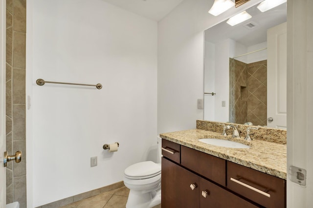 bathroom with tile patterned floors, vanity, toilet, and a tile shower