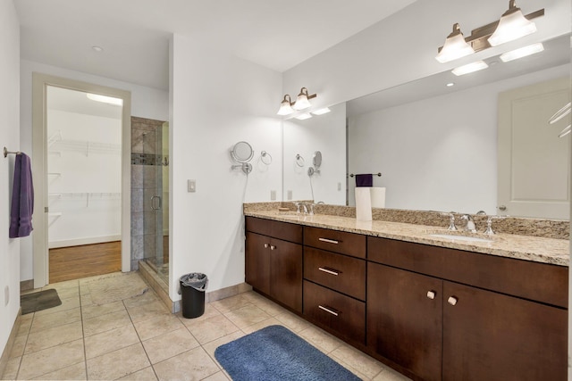 bathroom featuring tile patterned flooring, an enclosed shower, and vanity