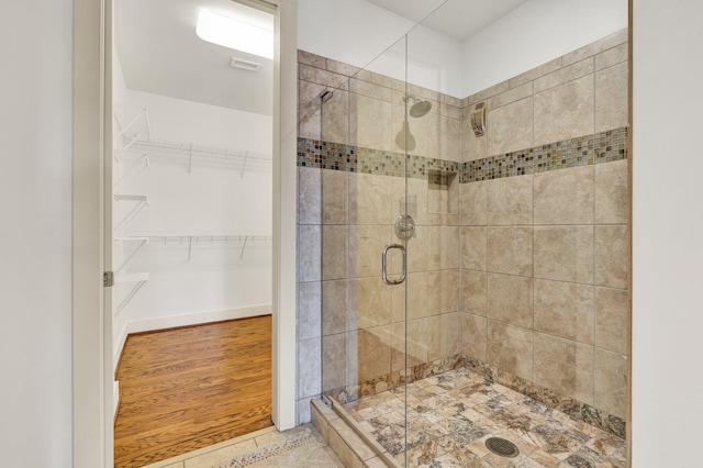 bathroom with wood-type flooring and a shower with door