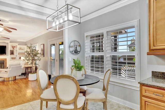 dining area featuring ceiling fan with notable chandelier, light tile patterned floors, and crown molding