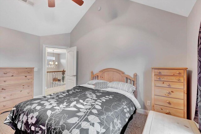 bedroom featuring ceiling fan with notable chandelier, carpet floors, and lofted ceiling