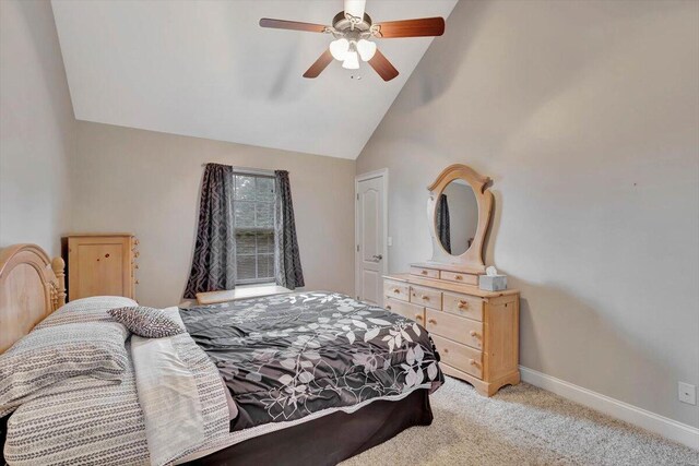 carpeted bedroom with ceiling fan and high vaulted ceiling