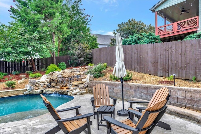 view of swimming pool featuring pool water feature, ceiling fan, and a patio