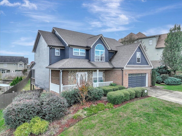 view of front of property with covered porch, a garage, and a front yard