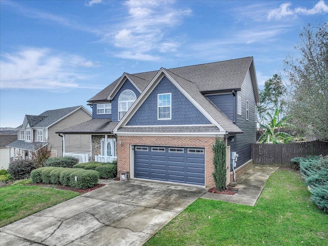 view of front facade with a front yard, fence, a shingled roof, concrete driveway, and brick siding