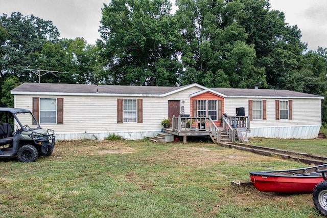 manufactured / mobile home with a front lawn and a wooden deck