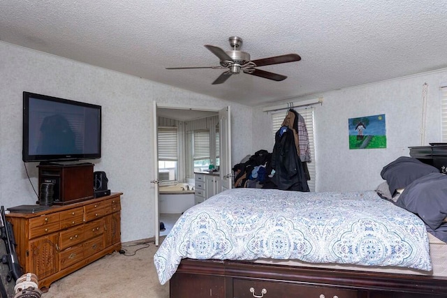 carpeted bedroom with ensuite bath, ceiling fan, and a textured ceiling