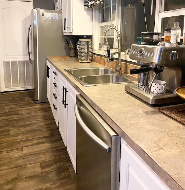 kitchen with dark hardwood / wood-style floors, sink, white cabinetry, and stainless steel appliances