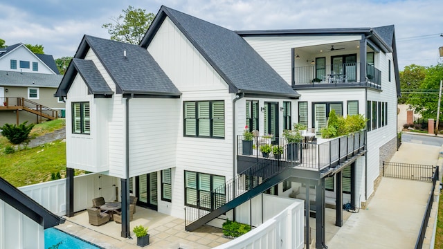 rear view of property featuring ceiling fan, a balcony, and a patio