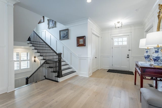 foyer featuring crown molding and light hardwood / wood-style flooring