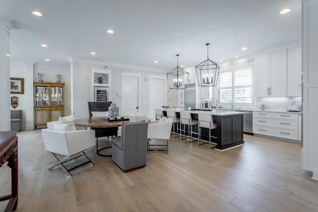 dining room with light hardwood / wood-style flooring and ornamental molding