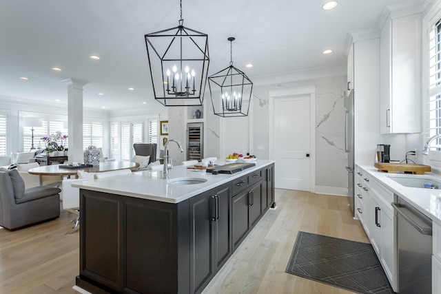 kitchen featuring dishwasher, a center island with sink, light hardwood / wood-style floors, and sink