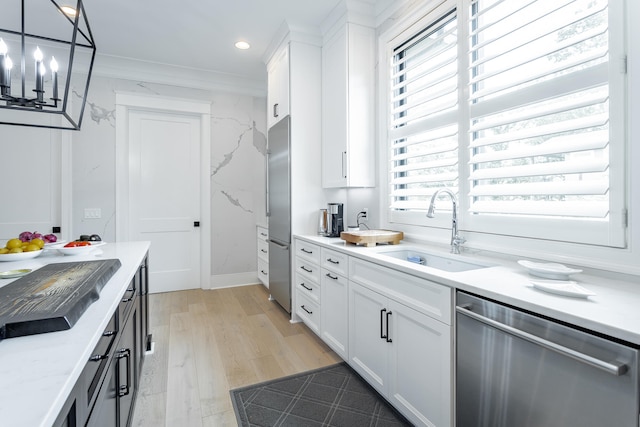 kitchen featuring appliances with stainless steel finishes, white cabinetry, a healthy amount of sunlight, and sink