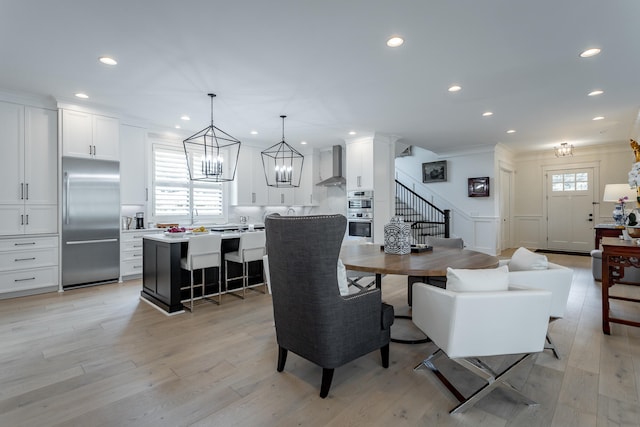 dining space featuring light hardwood / wood-style floors and ornamental molding