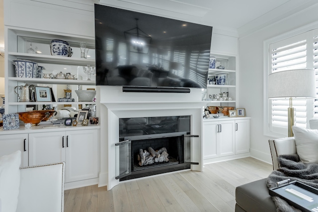 living room with light wood-type flooring and crown molding