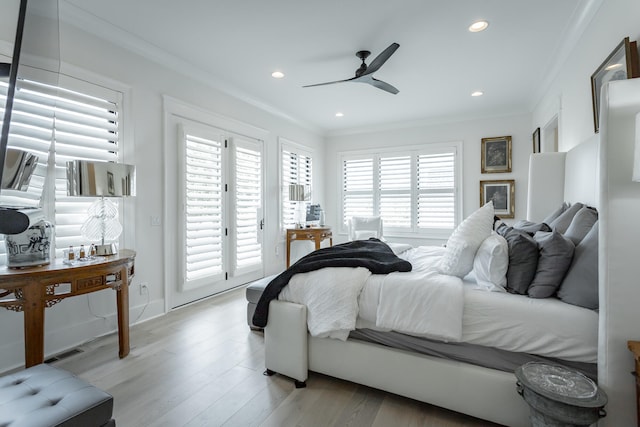 bedroom featuring access to outside, light hardwood / wood-style floors, multiple windows, and ceiling fan