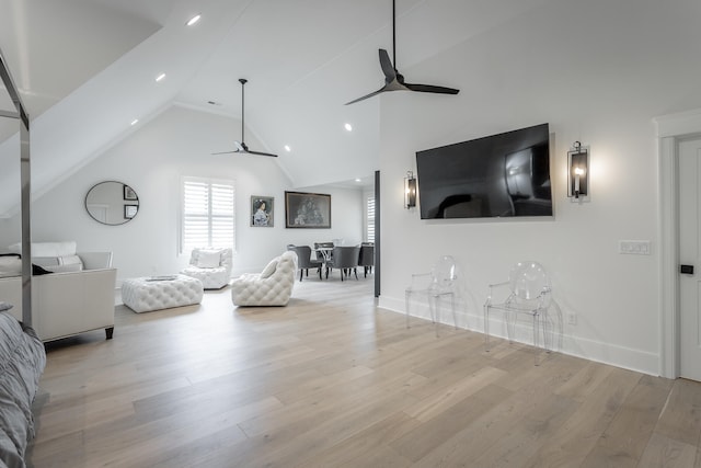 living room with ceiling fan, light wood-type flooring, and high vaulted ceiling