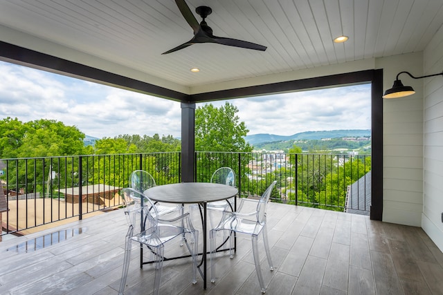 sunroom / solarium featuring a mountain view, ceiling fan, and a wealth of natural light