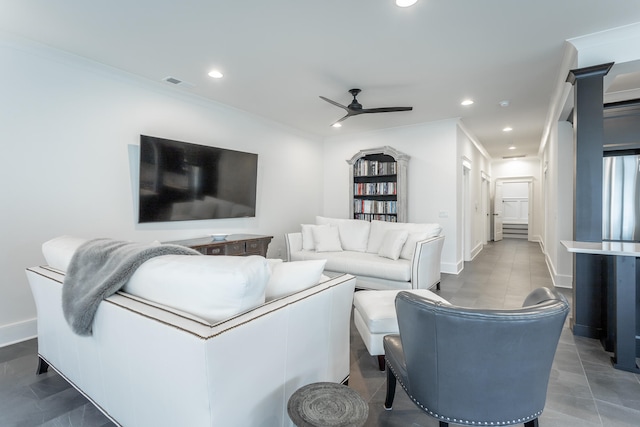 living room with dark tile patterned floors, ceiling fan, and ornamental molding