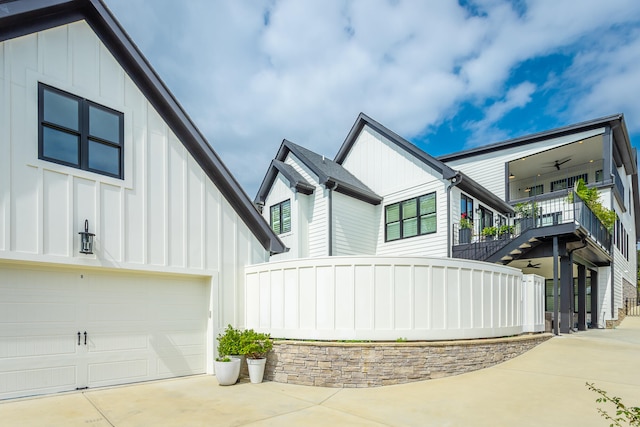 view of front of property with a balcony, a garage, and ceiling fan