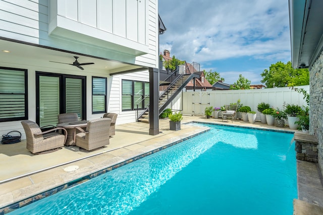 view of pool with a patio, pool water feature, and ceiling fan