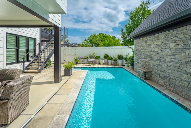 view of swimming pool featuring pool water feature and a patio area