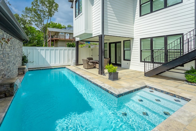 view of swimming pool featuring pool water feature and a patio