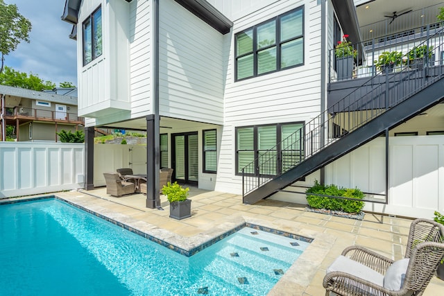 rear view of property featuring a fenced in pool, ceiling fan, and a patio