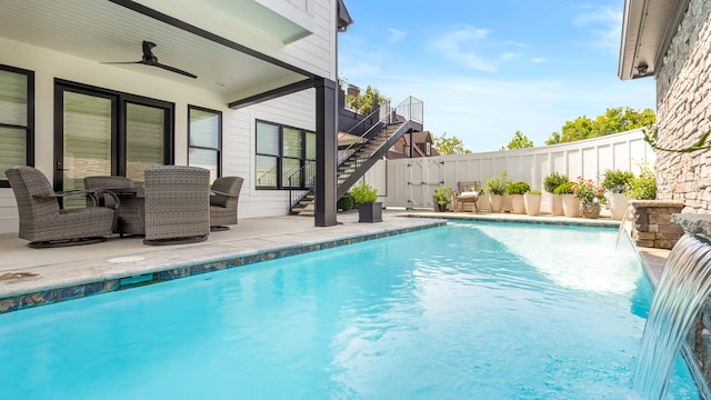 view of swimming pool with pool water feature, ceiling fan, and a patio area