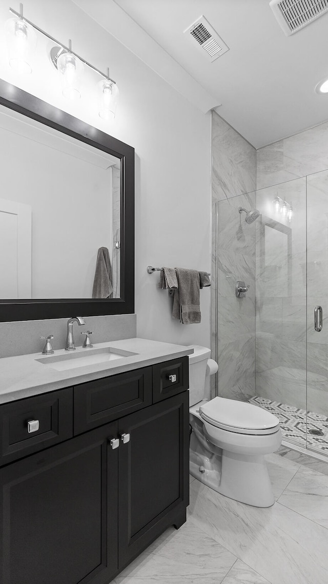 bathroom with vanity, toilet, and an enclosed shower