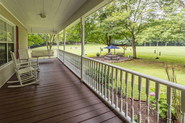 deck with a lawn and a porch