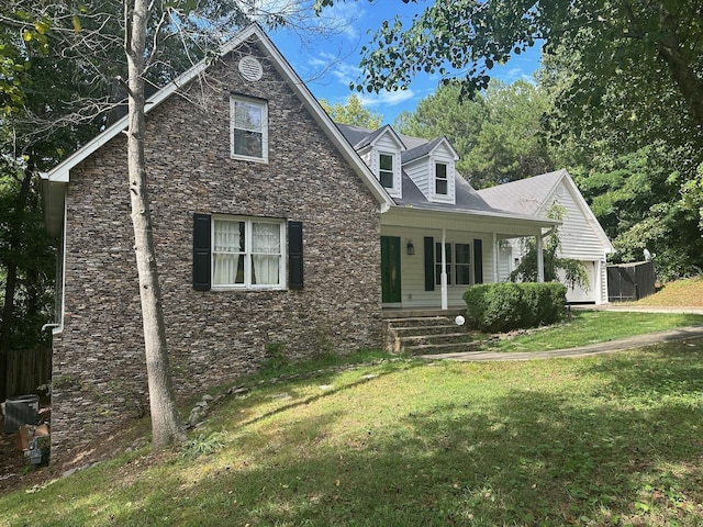 view of front of property with covered porch, central AC unit, and a front yard