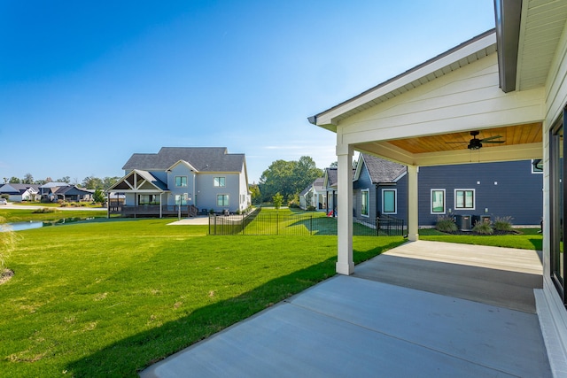 view of yard with ceiling fan, a water view, and central AC unit