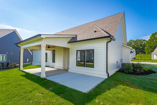 back of house featuring a lawn, a patio, and central air condition unit