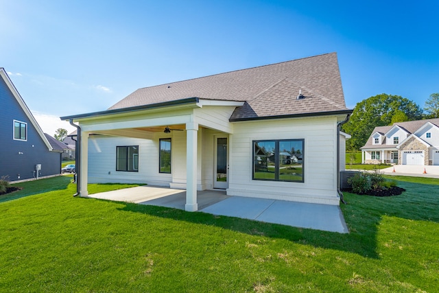 back of house with a lawn, a garage, and ceiling fan