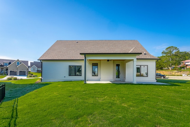 back of property featuring ceiling fan, a yard, and a patio