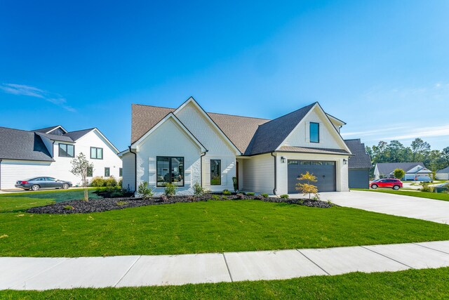 modern farmhouse featuring a front lawn and a garage