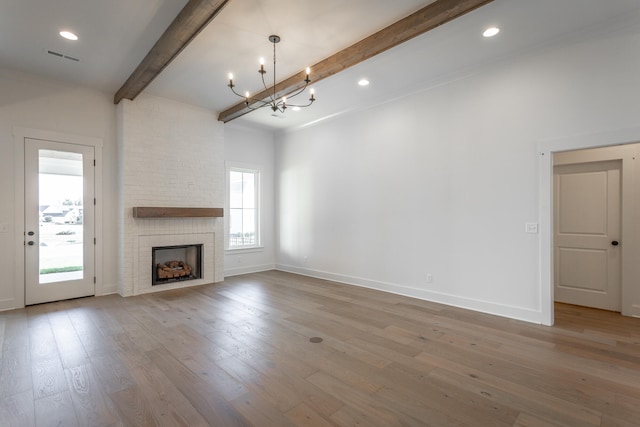 unfurnished living room with beamed ceiling, hardwood / wood-style floors, and a healthy amount of sunlight